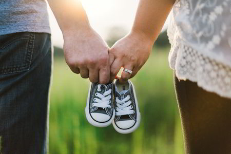 Parents talk while holding child's shoes